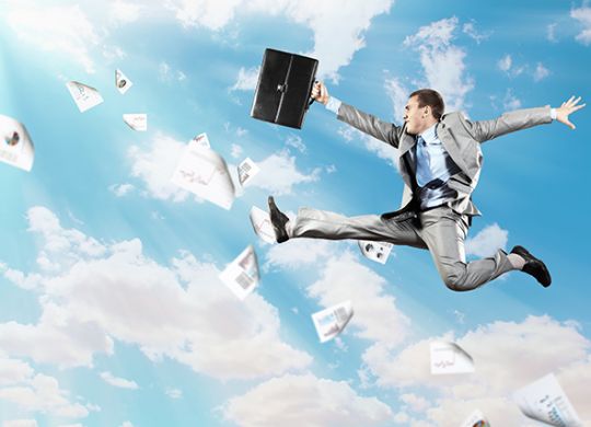 Image of a businessman jumping high against blue sky background